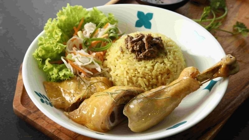 Bàn tay đang ghi chép kế hoạch ăn uống và calo, minh họa việc tính toán **một hộp cơm gà bao nhiêu calo** để kiểm soát cân nặng.