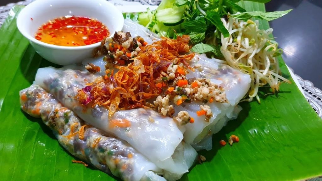 Bánh cuốn trình bày đẹp mắt cùng nước chấm chua ngọt, chả lụa và rau thơm, gợi lên hương vị đặc trưng của món ăn truyền thống.