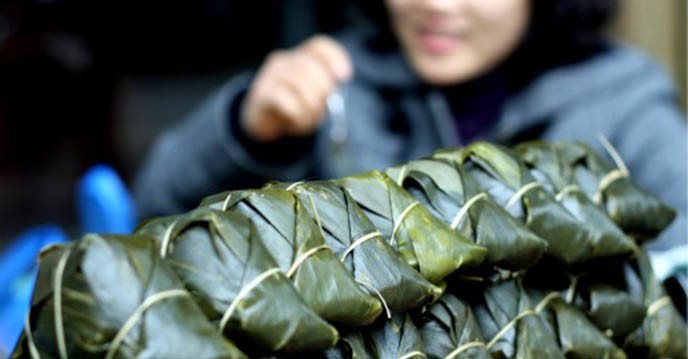 Bánh gio mật mía màu hổ phách đặt trên lá dong xanh mướt
