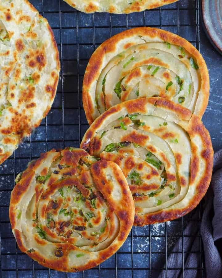 Bánh hành chiên sau khi rán được đặt trên giá để ráo dầu, giữ độ giòn hoàn hảo.