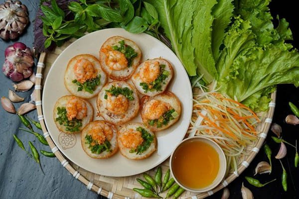 Bánh khọt nóng hổi ăn kèm rau sống tươi ngon và nước chấm chua ngọt