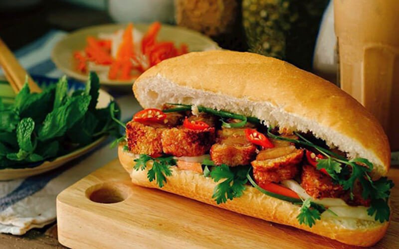 Bánh mì heo quay giòn rụm với lớp thịt và rau thơm ngon