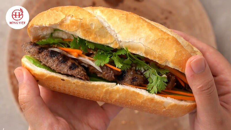 Bánh mì kẹp thịt xiên nướng với dưa chuột, rau thơm và nước sốt đặc trưng