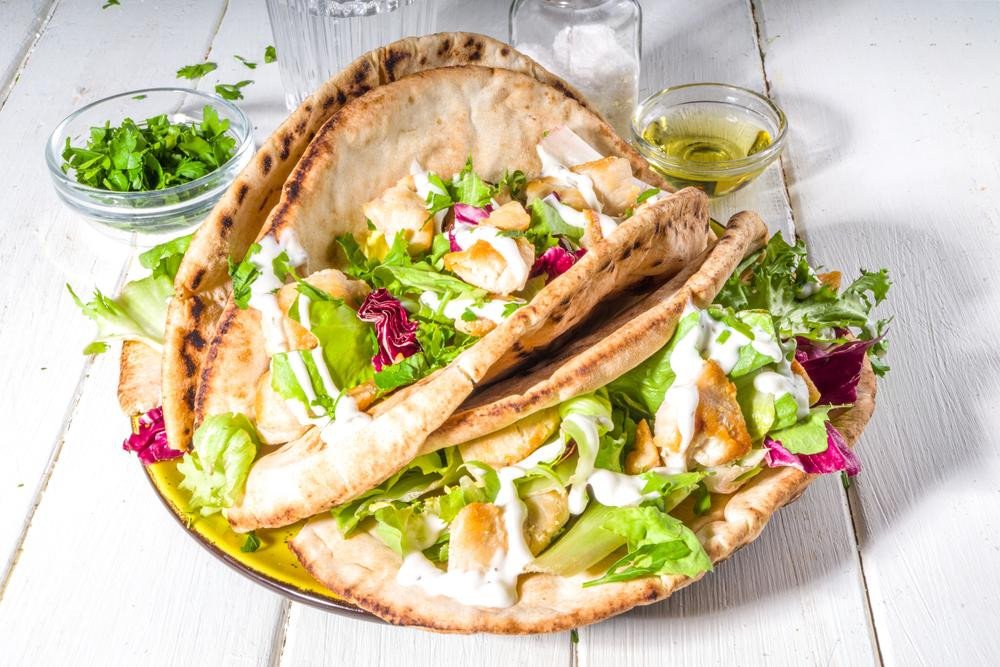Bánh mì pita kẹp gà áp chảo và rau xanh tươi ngon.