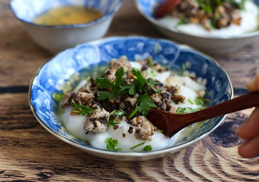 Bát bánh đúc nóng nghi ngút khói với thịt xào, rau thơm và nước chấm chua ngọt