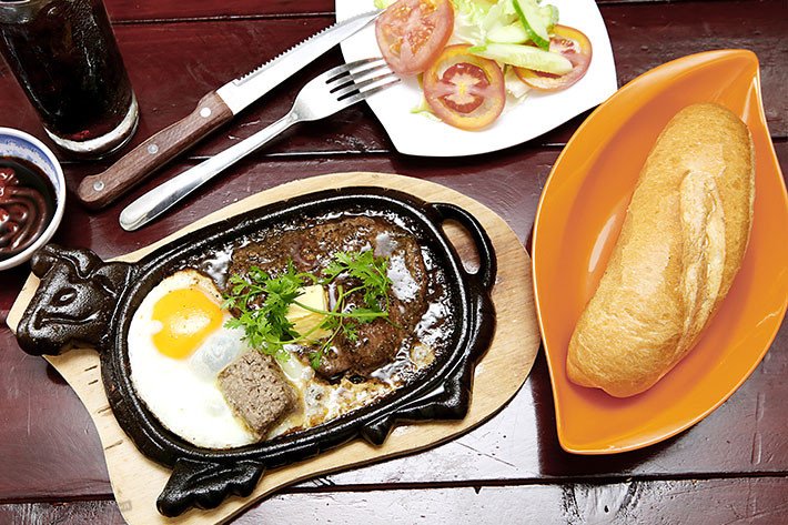 Bò bít tết ăn kèm trứng, khoai tây, salad và bánh mì