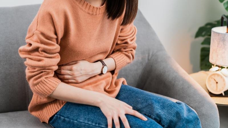 Bông cải trắng đặt cạnh lá cờ cảnh báo, nhấn mạnh những lưu ý khi sử dụng súp lơ trắng cho người có vấn đề tiêu hóa hoặc tuyến giáp