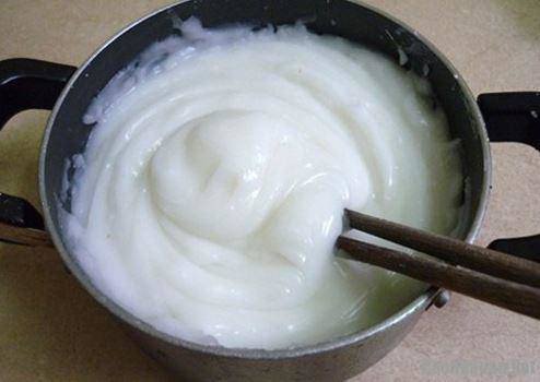 Bột bánh giò đang được nấu trên bếp, dần đặc lại và trong