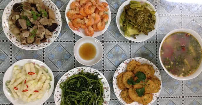 Bữa cơm gia đình với canh chua cá, tôm rim, rau lang xào và chân giò hầm sen