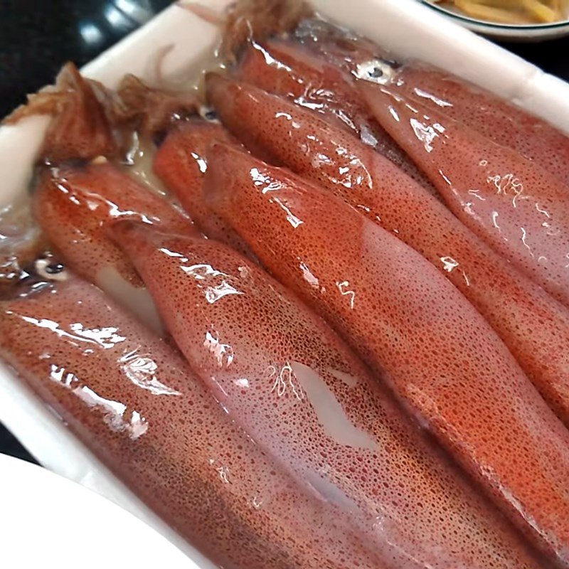 Bước sơ chế mực tươi: cắt bỏ mắt mực một cách cẩn thận