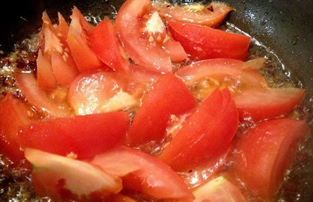 Cà chua bổ múi cau đang được xào chín mềm để làm nước dùng bún cá rô