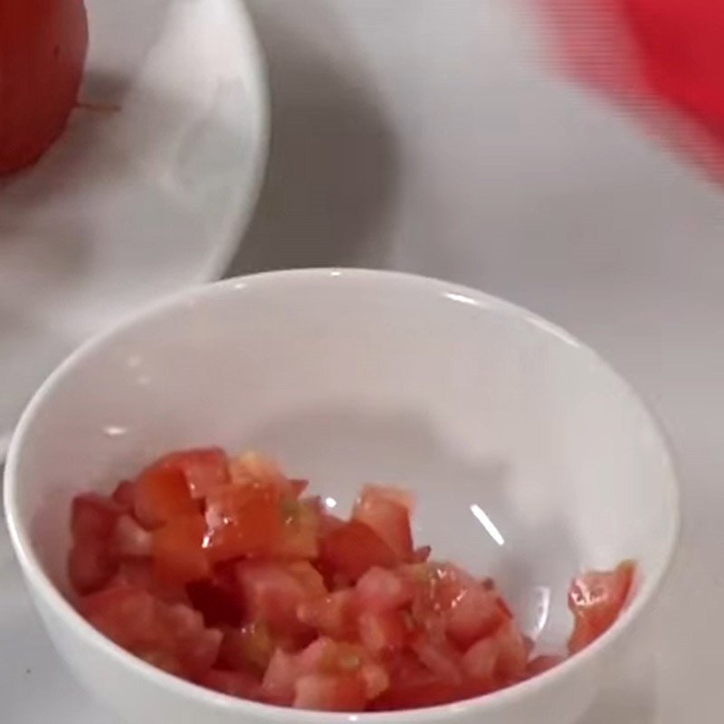 Cà chua được cắt múi cau và hạt lựu để chuẩn bị om mẻ
