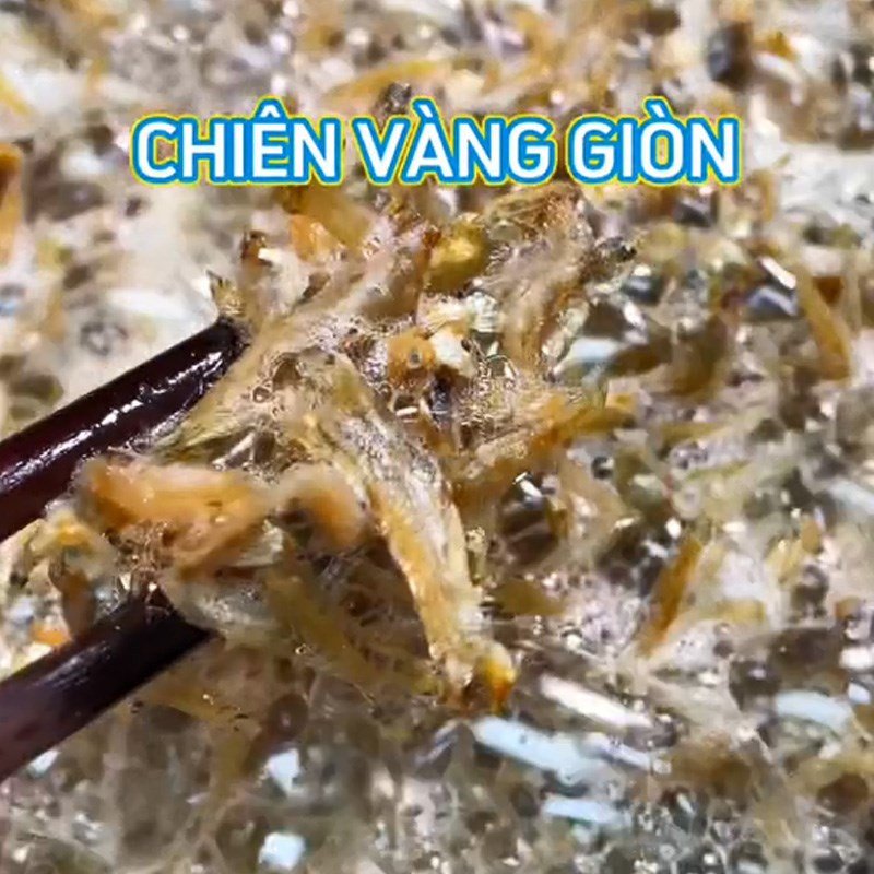 Cá cơm khô đang được chiên giòn trong chảo dầu nóng