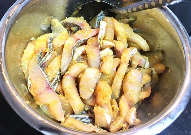Cá rô phi đang được ướp với nước cốt chanh và gia vị trước khi chiên
