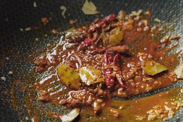 Các loại gia vị như sả, hành, tỏi, gừng đang được xào thơm để nấu gà cà ri