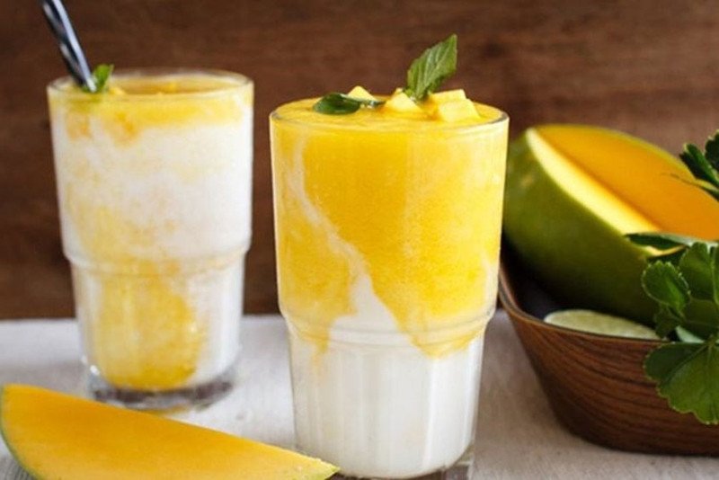 Các nguyên liệu cơ bản gồm xoài cắt miếng và sữa tươi, chuẩn bị làm sinh tố xoài.