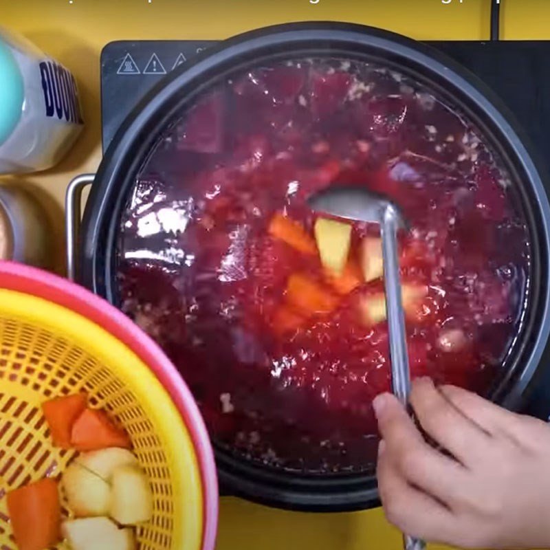 Canh củ dền với cà rốt và khoai tây đang được nấu trên bếp, màu sắc đẹp mắt