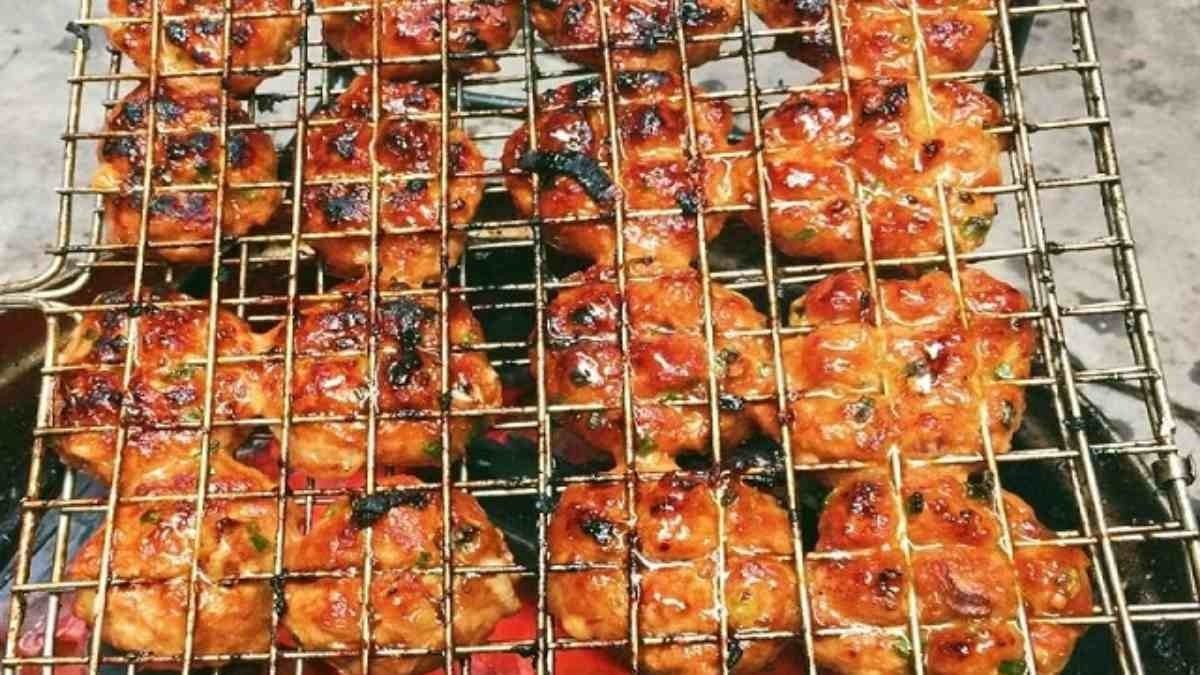 Chả thịt nướng đang được nướng trên bếp than hoa, toả mùi thơm hấp dẫn