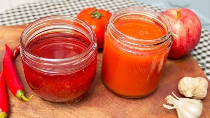 Chai tương ớt đỏ tươi đặt trên bàn gỗ, thể hiện lượng calo trong tương ớt