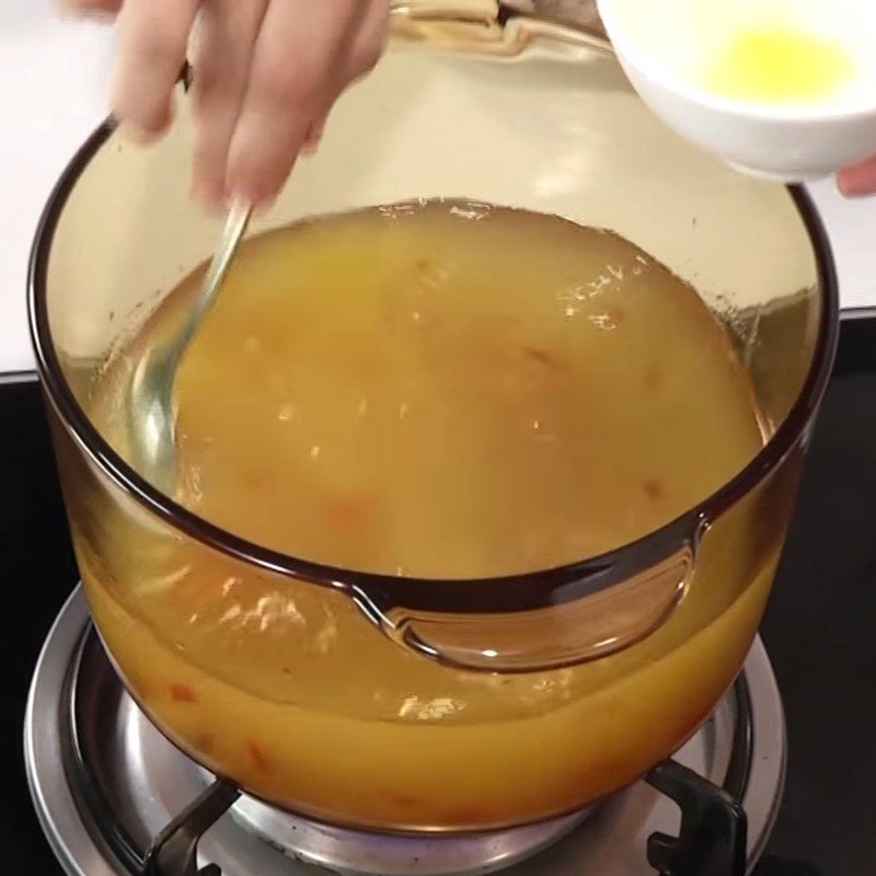 Cho nước và cà chua đã xào vào nồi để nấu món om mẻ