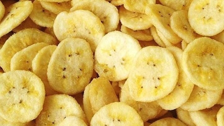 Chuối phơi khô được cắt lát và phơi nắng trên khay để làm mất nước, tối ưu hóa dinh dưỡng và hương vị.
