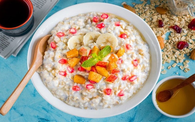 Cô gái trẻ thưởng thức bữa sáng với cháo yến mạch lành mạnh