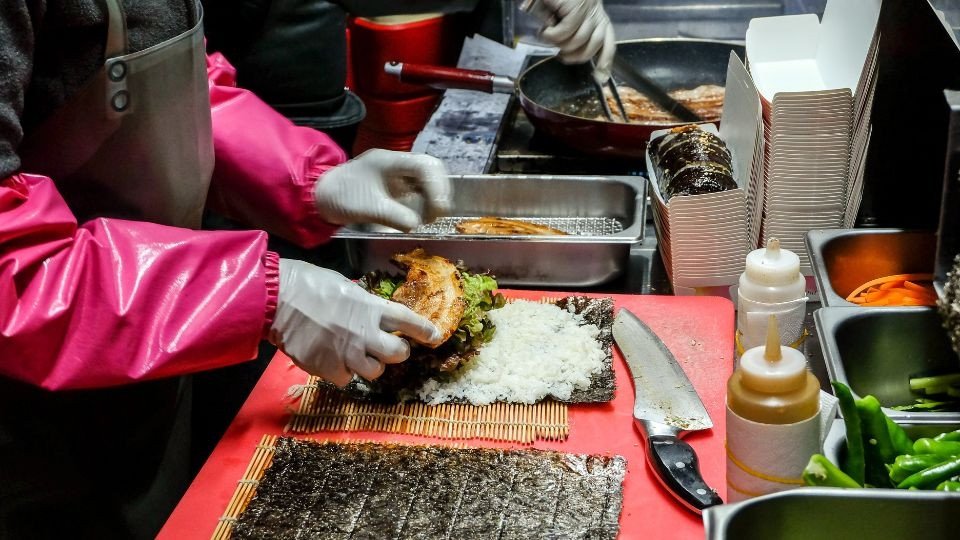 Cuộn kimbap chặt tay, đều đặn trên mành tre