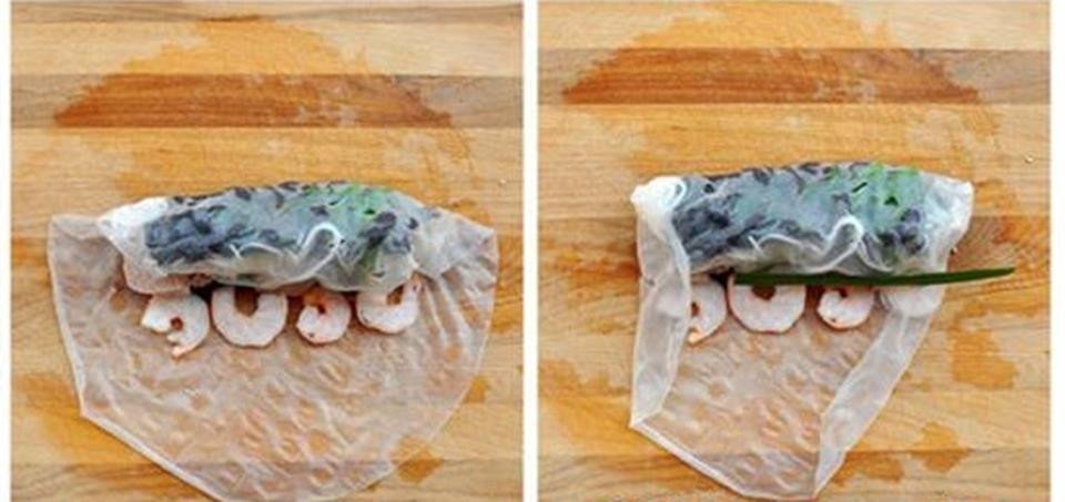 Đặt tôm tươi và lá hẹ vào giữa bánh tráng đang cuốn để gỏi cuốn tôm thịt thêm đẹp mắt