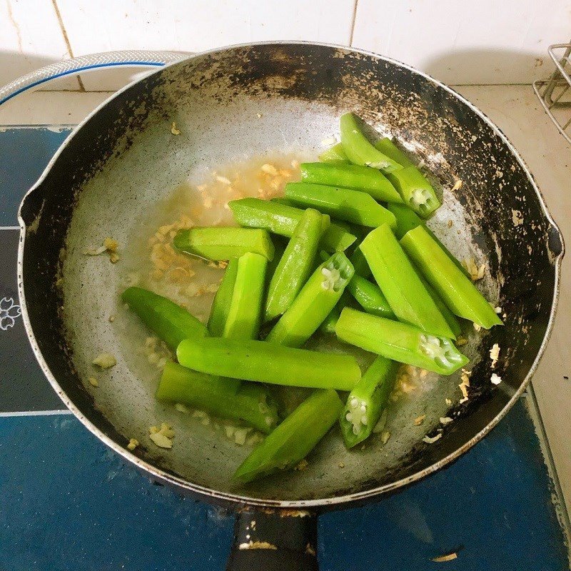 Đậu bắp đang được xào cùng tỏi trên chảo
