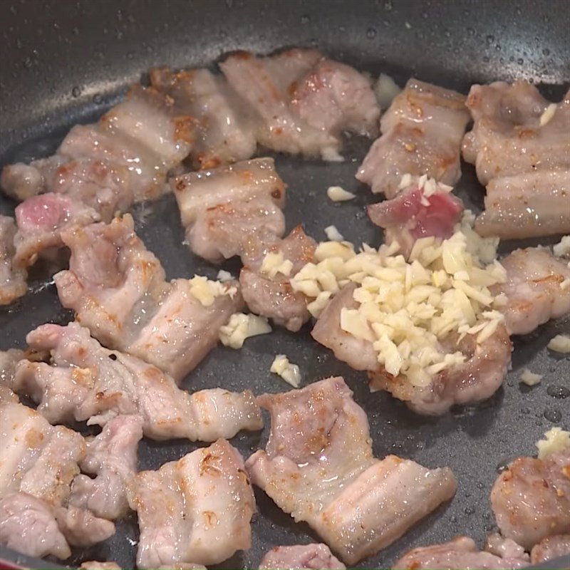 Đầu bếp đang xào thịt ba chỉ và củ hũ dừa trong chảo lớn