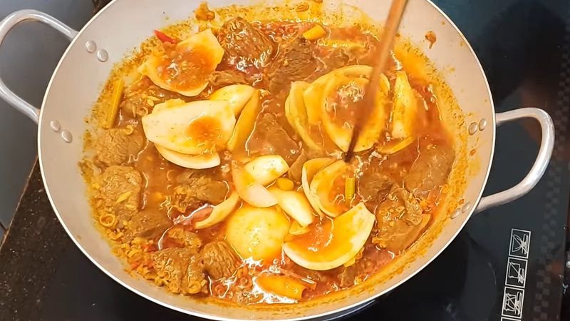 Đầu bếp đang xào thịt đà điểu cùng các loại rau củ trên chảo nóng