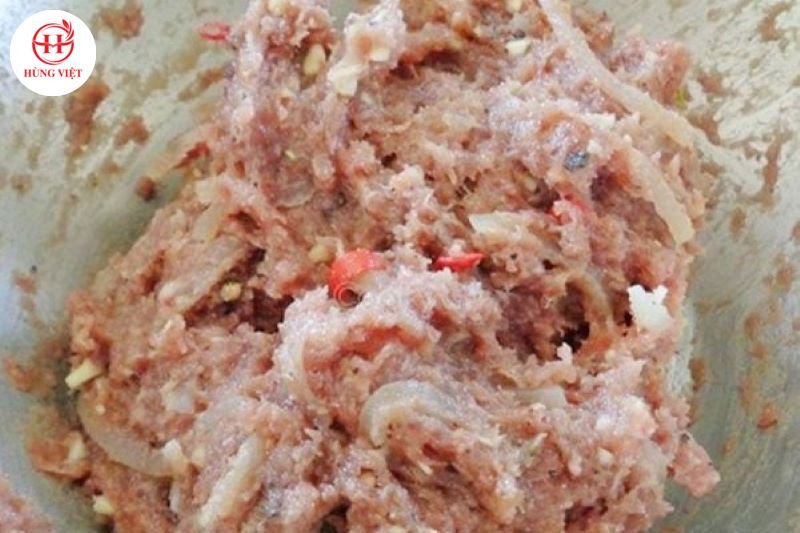 Đeo găng tay trộn nem từ thịt lợn sống cho đều gia vị