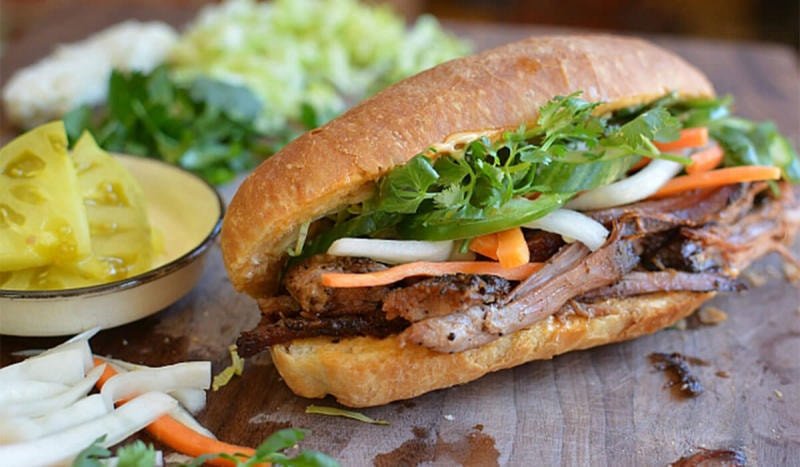 Đĩa bánh mì pate đầy đủ rau củ và topping, thể hiện sự đa dạng dinh dưỡng.