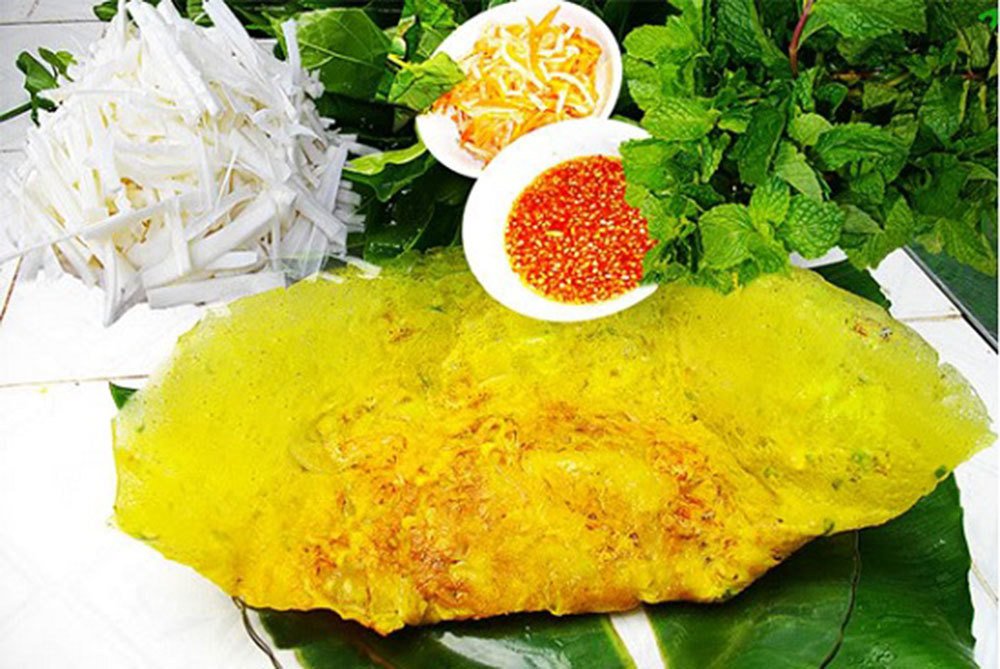 Đĩa bánh xèo miền Nam vàng giòn, nhân tôm thịt đầy đặn, ăn kèm rau sống và nước chấm chua ngọt