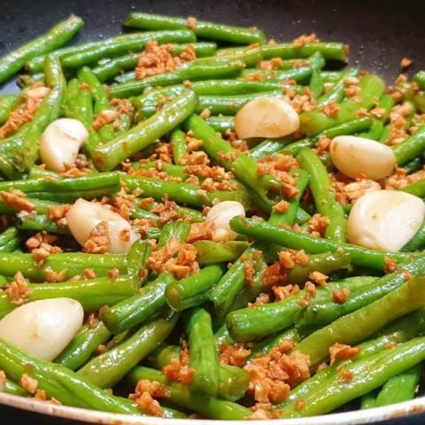 Đĩa đỗ xào tỏi xanh mướt trên bàn ăn, chuẩn bị thưởng thức