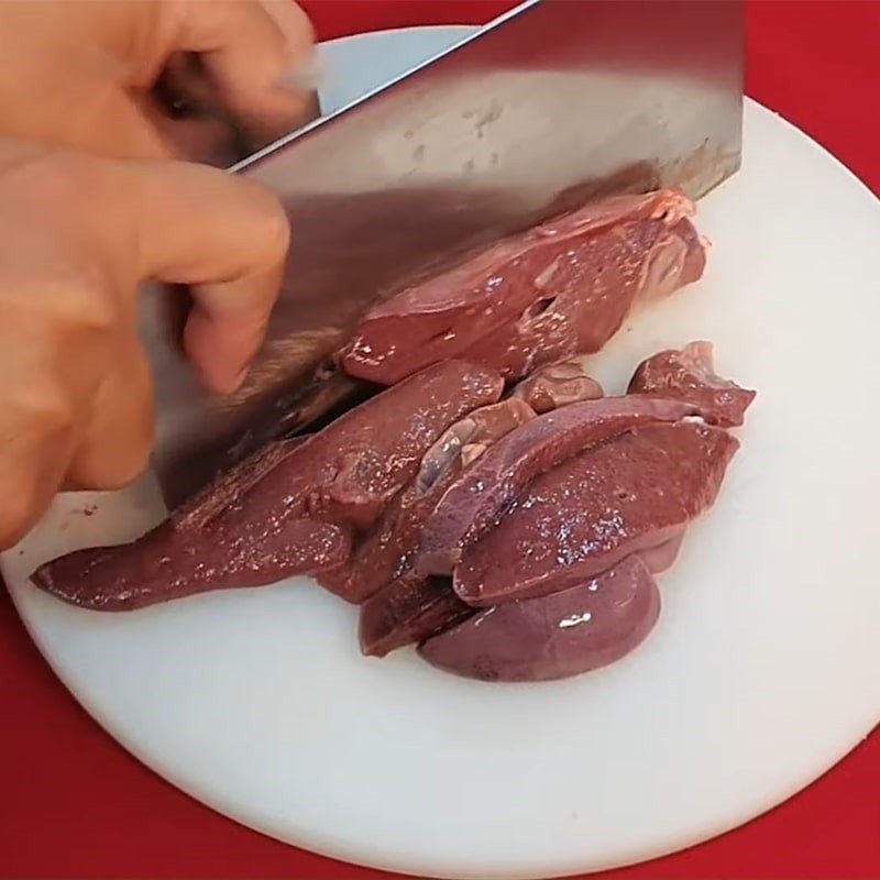 Đĩa gan heo đang được trộn đều với các gia vị như muối, đường, hạt nêm để thấm vị