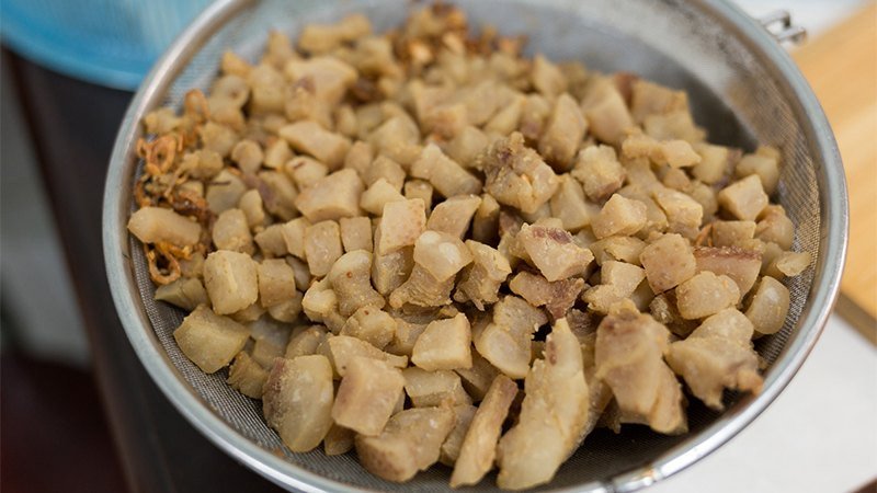 Đĩa mỡ lợn tươi và tóp mỡ vàng giòn, minh họa lượng calo trong 10g mỡ lợn.