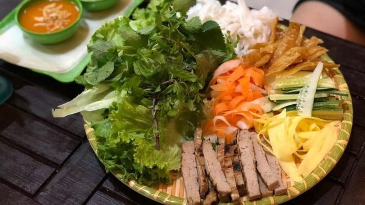 Đĩa nem nướng Nha Trang đầy đặn với rau sống, chả giò và nước chấm, thể hiện sự đa dạng về calo.