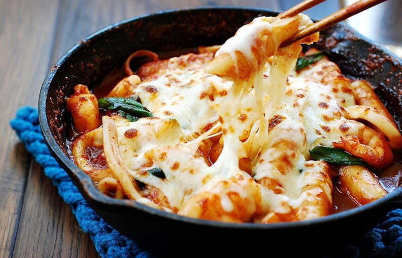 Đĩa tokbokki nhân phô mai nóng hổi, phô mai tan chảy quyện với bánh gạo và nước sốt.