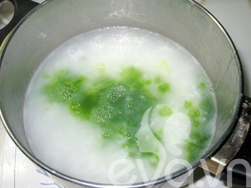 Đổ nước cốt lá dứa xanh vào nồi cháo đang nấu để tạo màu và hương vị