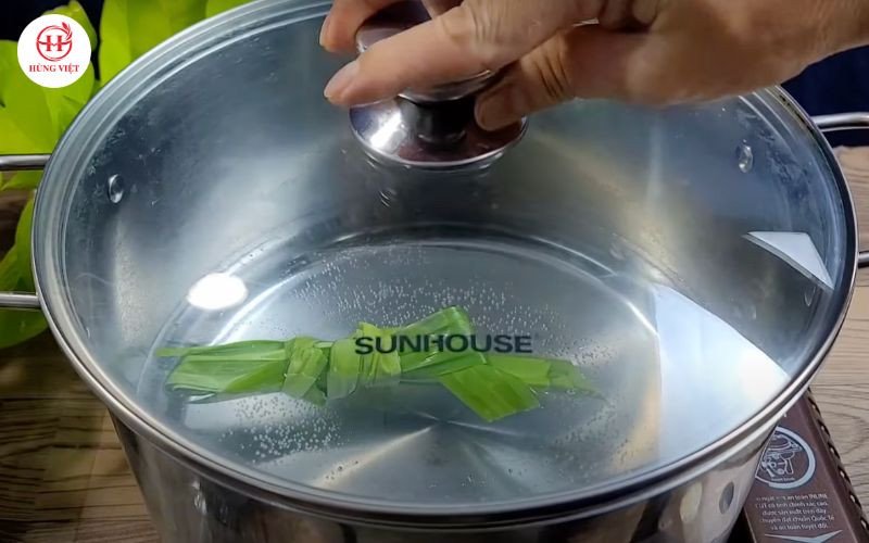 Đun sôi nước với lá dứa để hấp xôi