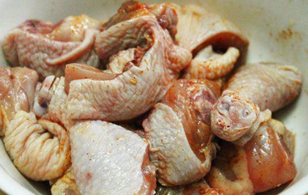Gà ta chặt miếng lớn đang được ướp gia vị