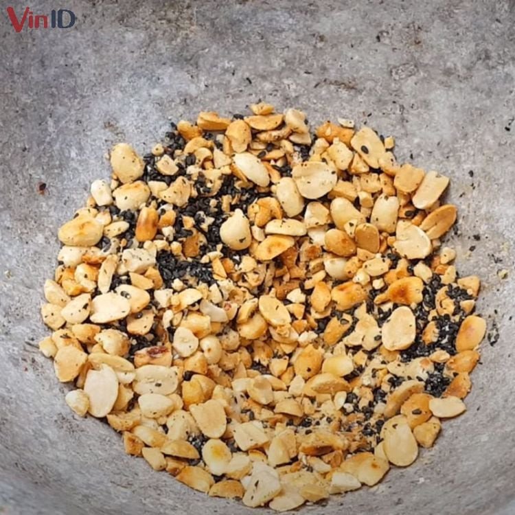 Giã đậu phộng và mè rang để rắc lên chè khoai mì