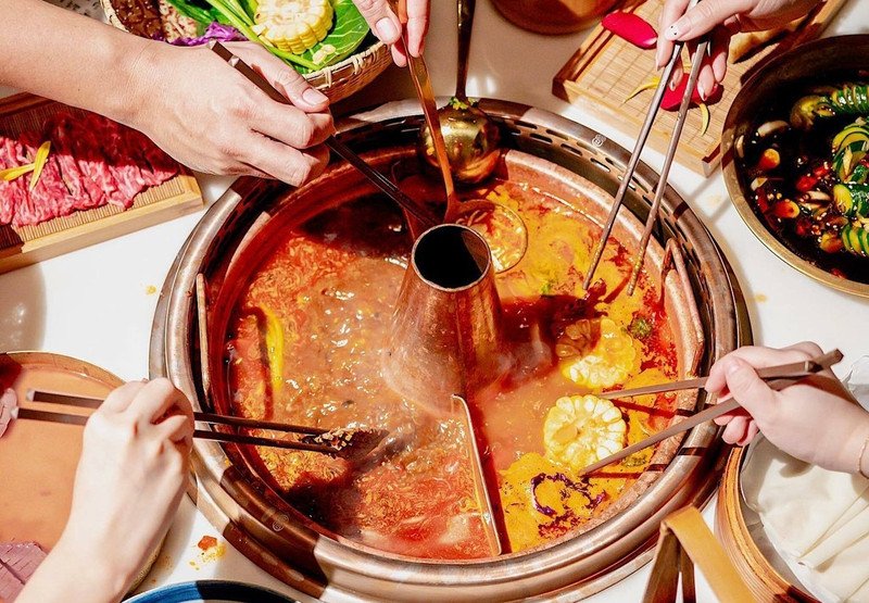 Gia đình quây quần bên nồi lẩu cá, thể hiện việc kiểm soát khẩu phần để lẩu cá bao nhiêu calo không vượt quá ngưỡng cho phép