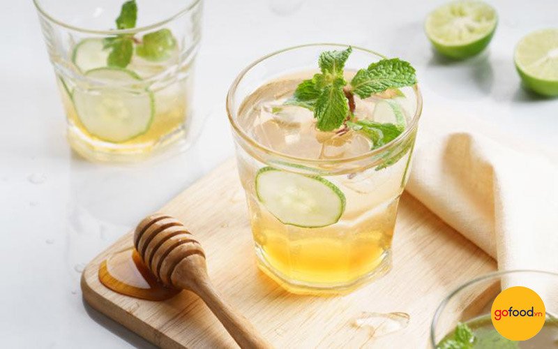 Hai ly nước chanh mật ong đặt cạnh nhau, nhắc nhở về việc tiêu thụ điều độ mỗi ngày.