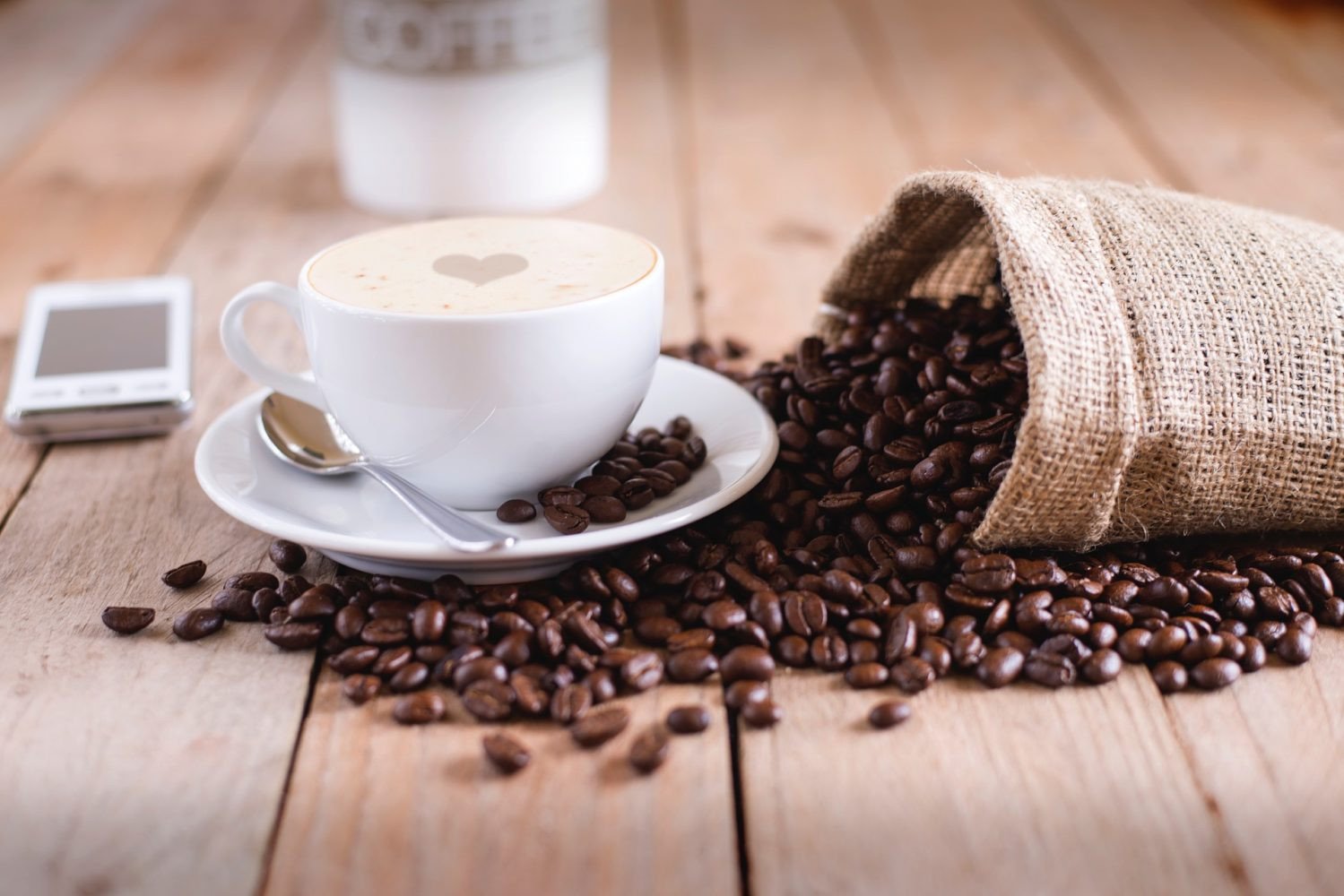 Hạt cà phê và ly espresso, minh họa lợi ích và tác hại liên quan đến cà phê Kopiko Macchiato bao nhiêu calo