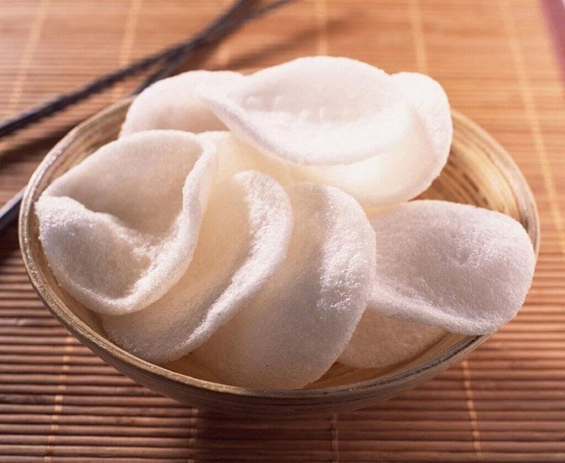 Hình ảnh bánh phồng tôm chiên vàng rụm, xếp chồng lên nhau trên đĩa, minh họa rõ nét cách chế biến phổ biến sử dụng nhiều dầu mỡ, làm tăng đáng kể lượng calo.