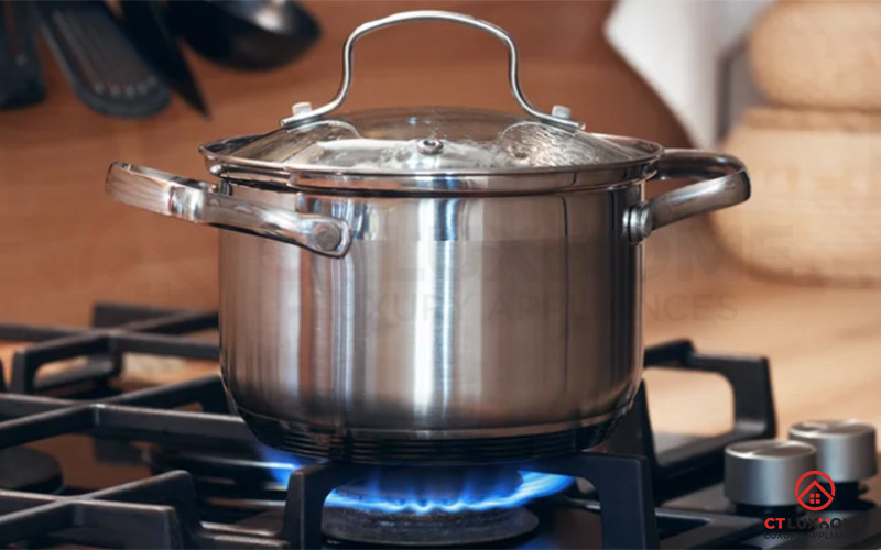 Hình ảnh một người đang múc cháo trắng từ nồi ra bát trên bàn ăn gia đình.