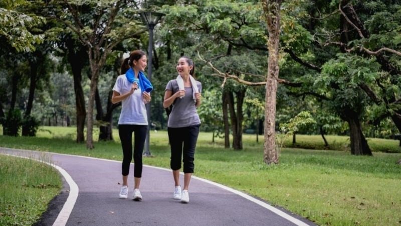 Hình ảnh người phụ nữ đang chạy bộ ngoài trời, minh họa lợi ích của việc vận động thường xuyên trong quá trình tiêu hao calo và giữ dáng