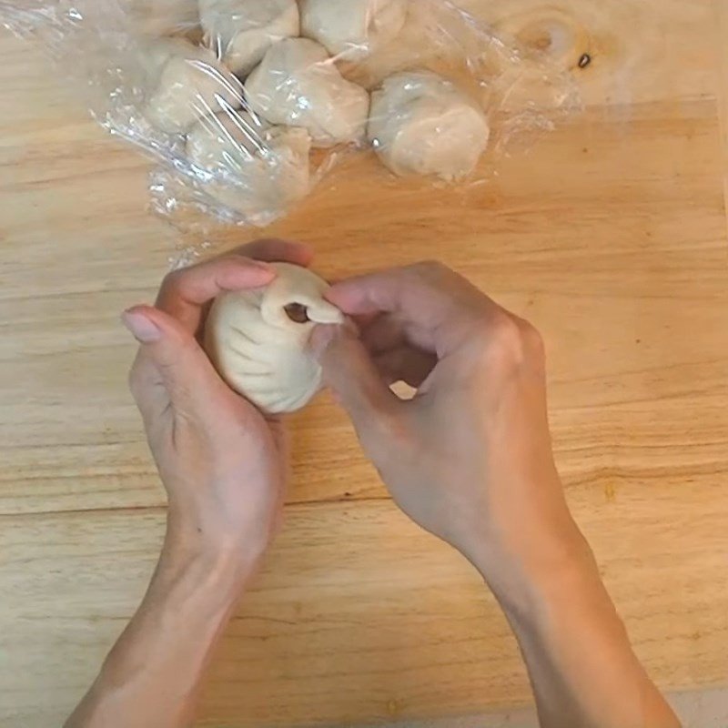 Hoàn thiện việc tạo hình bánh bao với các nếp gấp đẹp mắt, sẵn sàng để hấp.